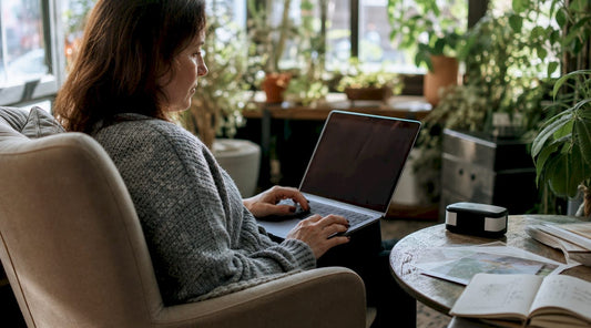 Woman checking custom print proofs on calibrated monitor