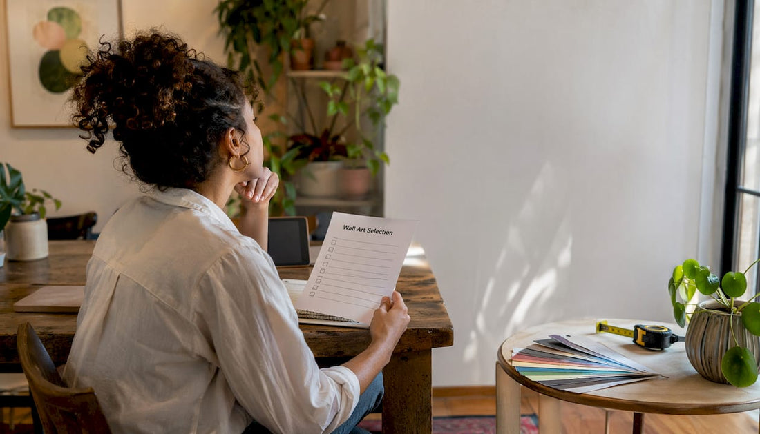 Woman planning wall art placement at home