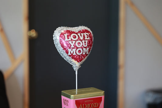 a heart shaped balloon sitting on top of a box